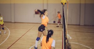 A woman hitting a volleyball spike.