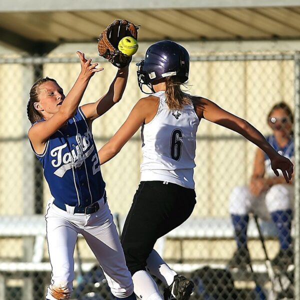 a softball players catching a ball