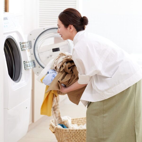 mom putting laundry in washer