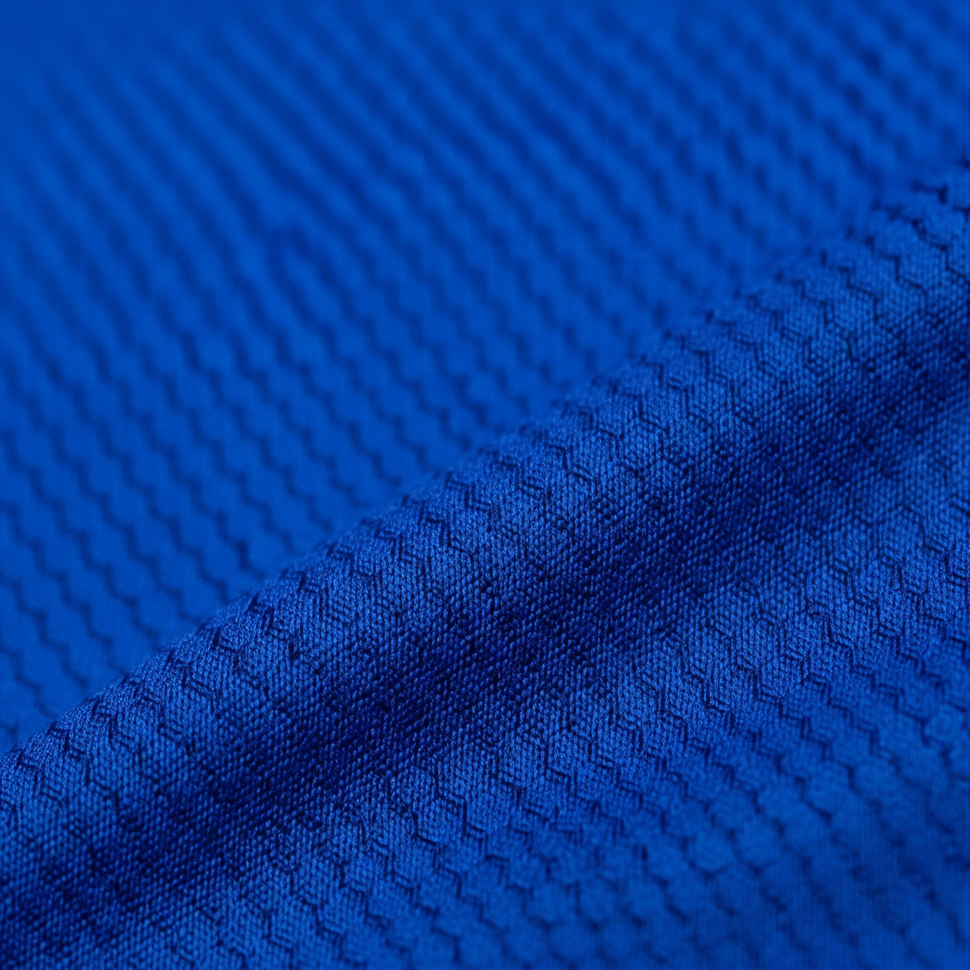A close-up of a high-performance, moisture-wicking fabric swatch with a subtle, technical pattern.