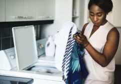 mom putting laundry in washer